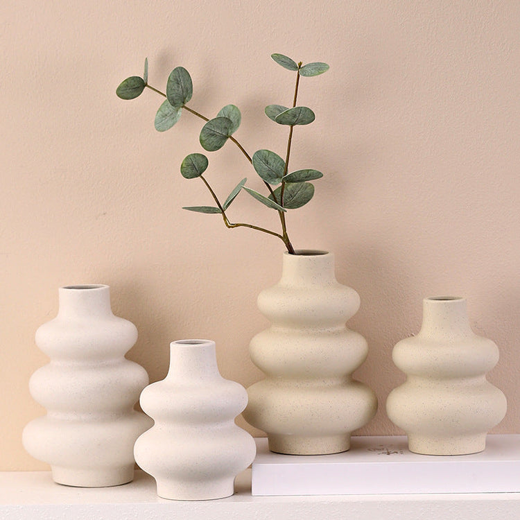 Nordic ceramic gourd vase on an entryway console with a wooden tray