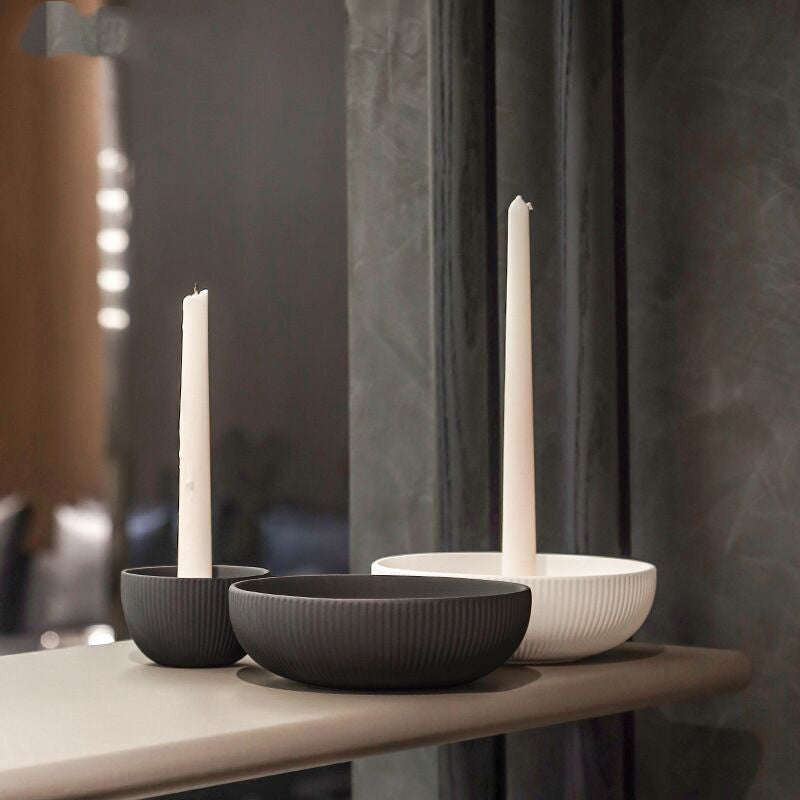 Simple ceramic candle tray holding a lit candle